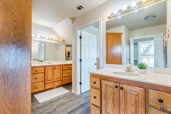 a bathroom with a sink double vanity granite tub shower and a mirror