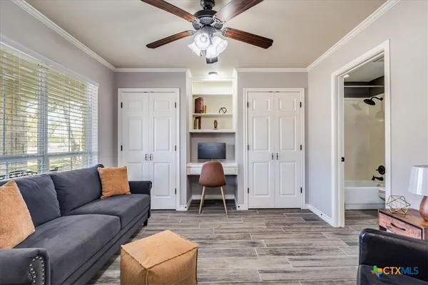 a living room with furniture ceiling fan and a window