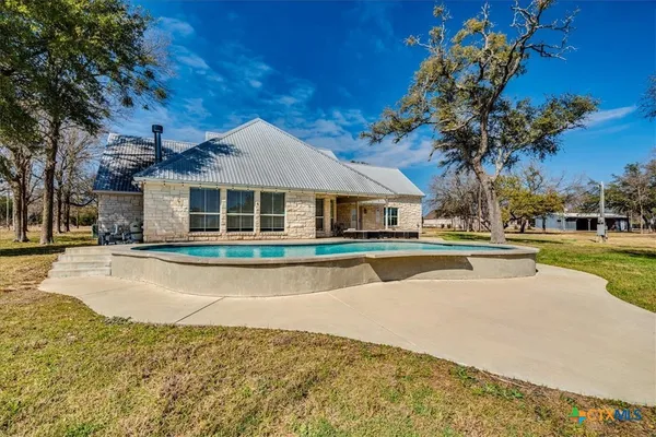 a view of house with outdoor space and swimming pool