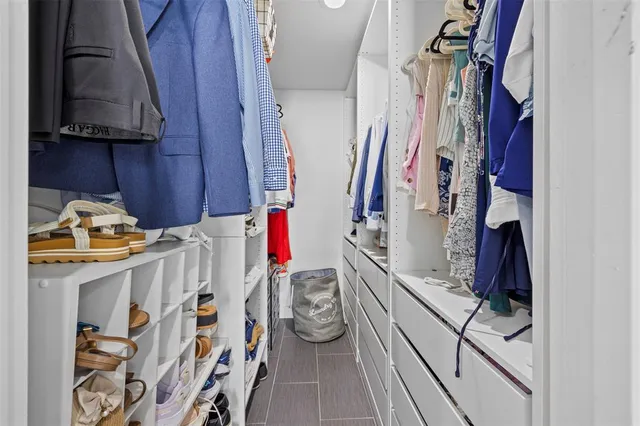 a view of walk in closet with clothes and shoes