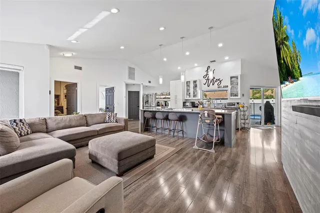 a living room with furniture and a view of kitchen