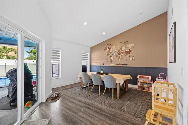 a view of a dining room with furniture a chandelier and wooden floor