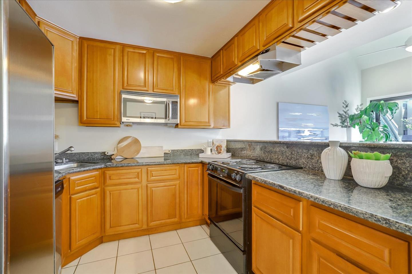 7 Embarcadero West, Unit 115 Oakland, CA 94607 - Photo 10 of 39 a kitchen with a sink a stove and cabinets