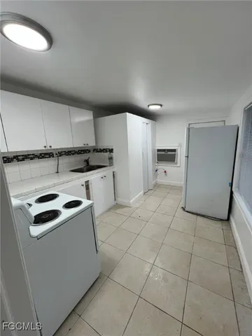 a kitchen with granite countertop a sink a stove and cabinets