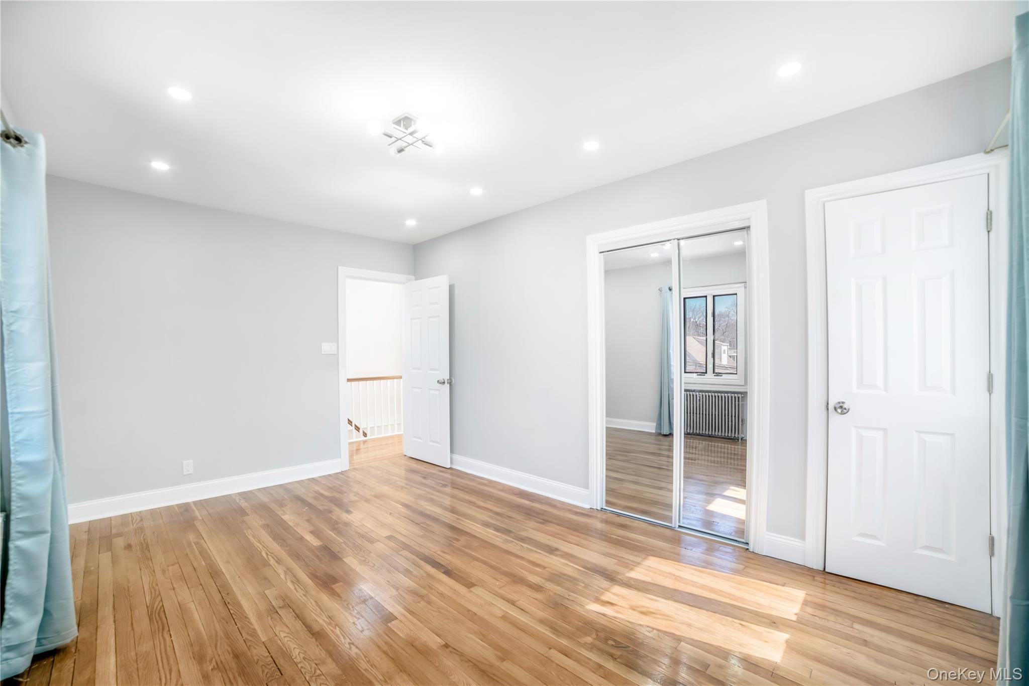 81-28 252nd Street Queens, NY 11426 - Photo 14 of 21 an empty room with wooden floor and windows
