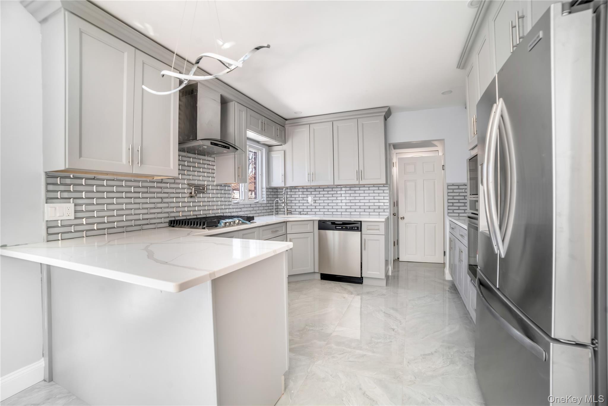 81-28 252nd Street Queens, NY 11426 - Photo 5 of 21 a kitchen with stainless steel appliances a refrigerator sink and cabinets