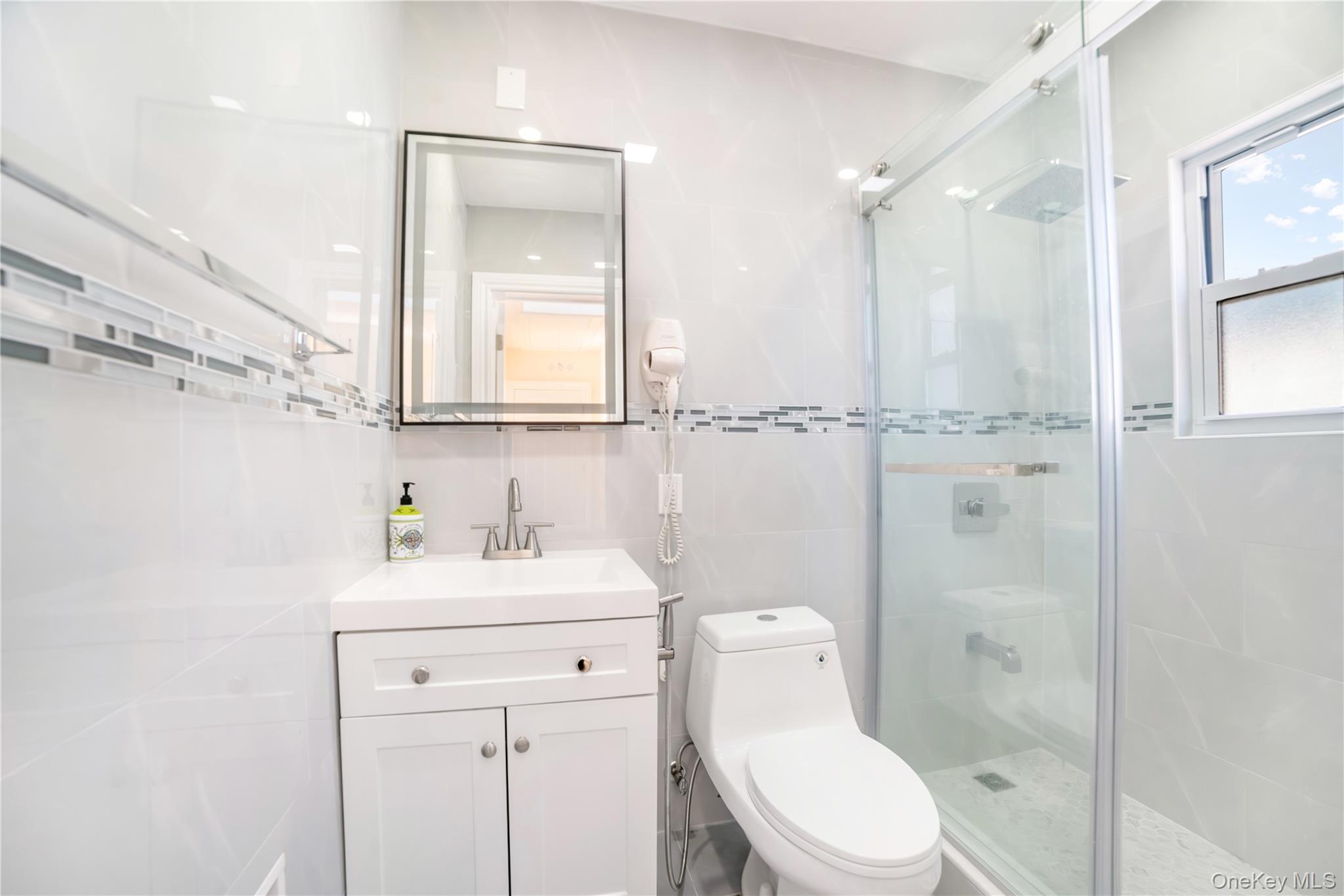 81-28 252nd Street Queens, NY 11426 - Photo 10 of 21 a bathroom with a toilet sink vanity and mirror