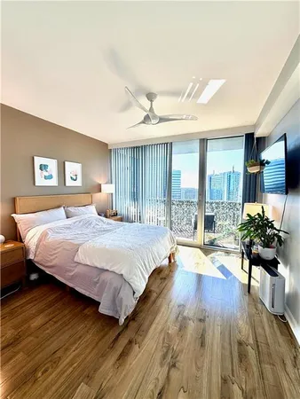 a spacious bedroom with a bed and wooden floor