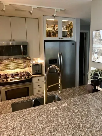 a kitchen with kitchen island granite countertop a stove and a refrigerator