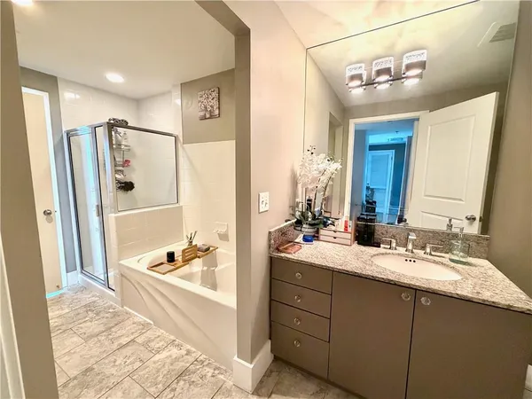 a bathroom with a double vanity sink a mirror and a bathtub