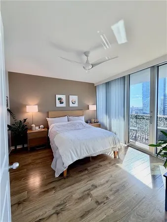 a spacious bedroom with a bed windows and a table