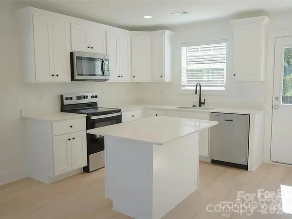 a kitchen with stainless steel appliances a sink stove and window