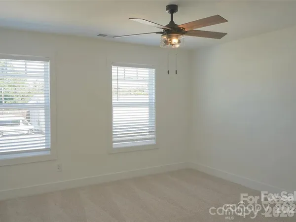 an empty room with a window and a fan