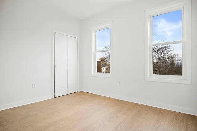 an empty room with windows and closet