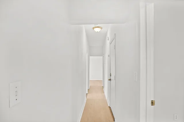 a view of a bedroom with wooden floor and a window