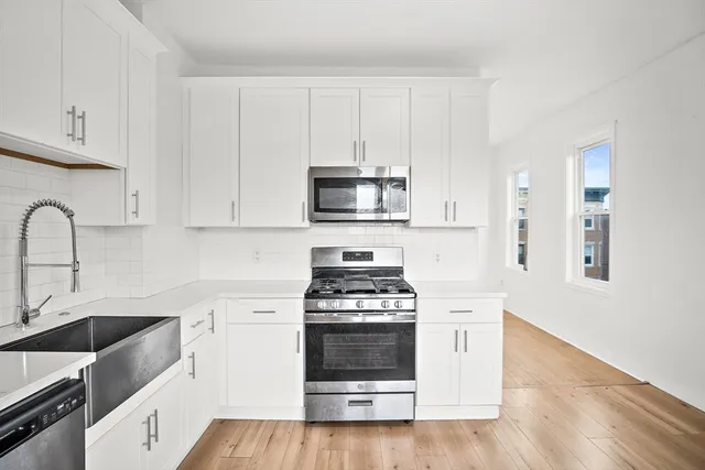 a kitchen with granite countertop white cabinets and white appliances