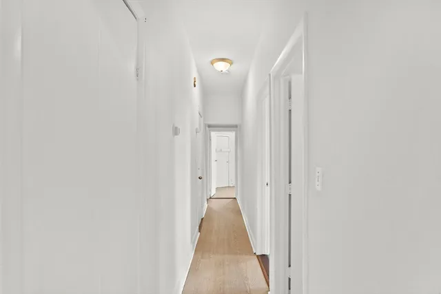 a view of a hallway with wooden shelves