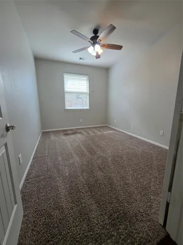 en empty room with windows and fan