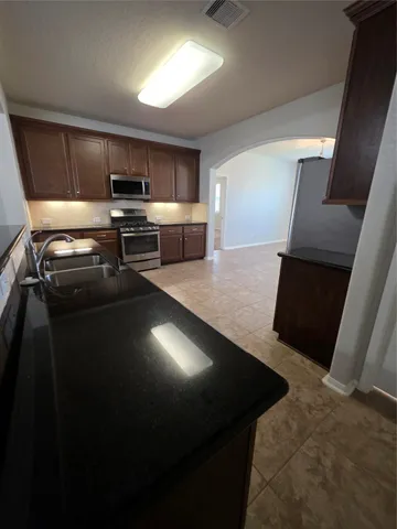 a kitchen with a sink stainless steel appliances and cabinets