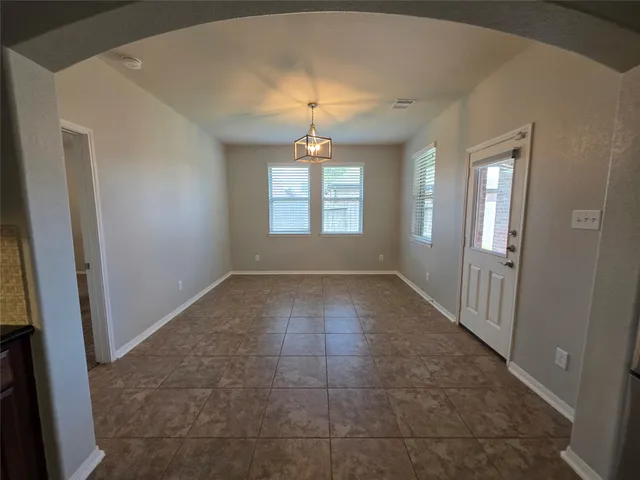 an empty room with windows and fireplace