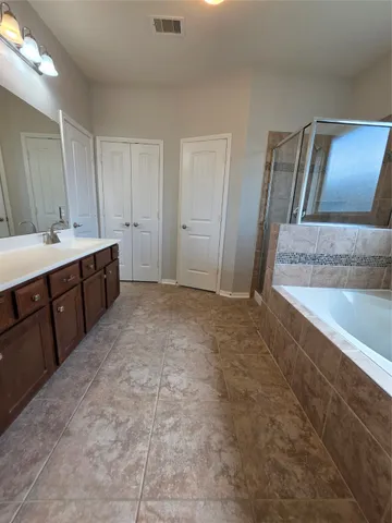 a spacious bathroom with a granite countertop sink and a mirror