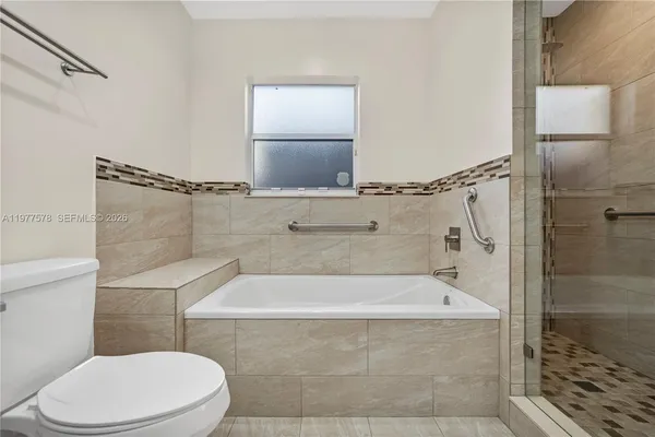 a bathroom with a white toilet and a bathtub
