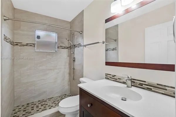 a bathroom with a sink toilet a mirror and shower