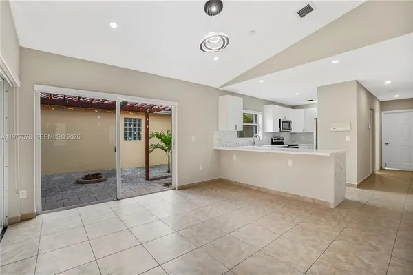 a large white kitchen with a sink and cabinets