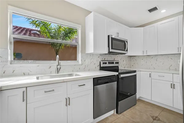 a kitchen with a sink stove and microwave