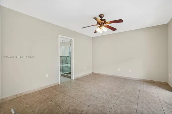 an empty room with windows and fan