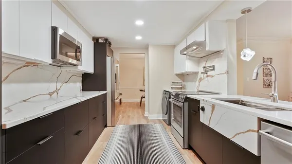a kitchen with stainless steel appliances granite countertop a sink stove and refrigerator