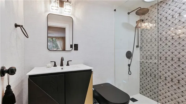 a bathroom with a sink a toilet and shower