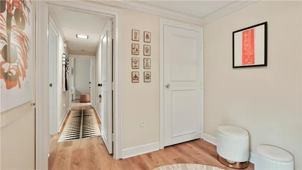 a view of a hallway with wooden floor and a bathroom
