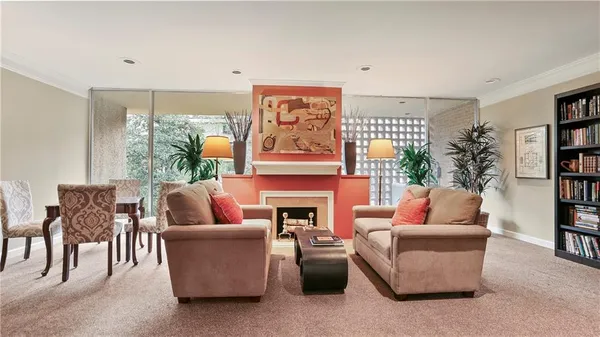 a living room with furniture a fireplace and a large window