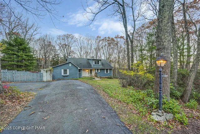 a front view of a house with a yard and trees
