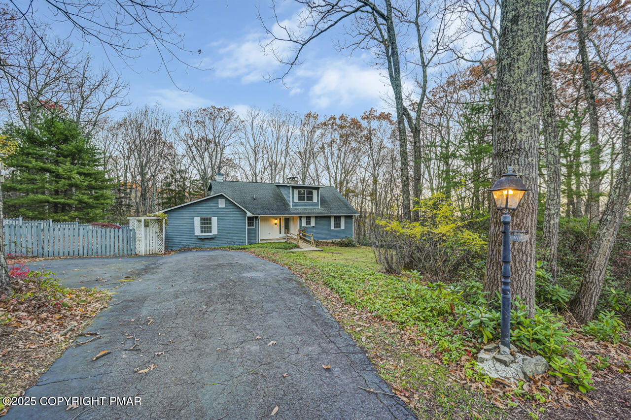 a front view of a house with a yard and trees