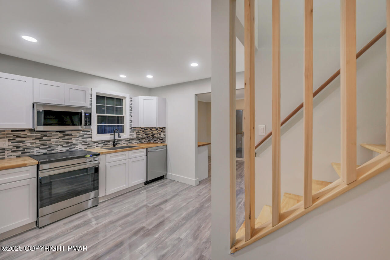 384 Devils Hole Road Cresco, PA 18326 - Photo 20 of 97 a kitchen with stainless steel appliances kitchen island granite countertop a stove a sink and a microwave