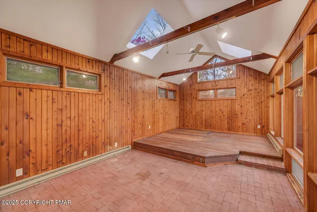a view of empty room with wooden floor and window