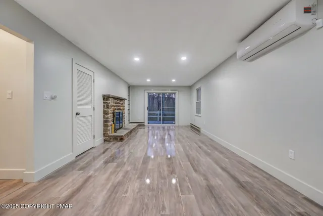 a view of an empty room with a wooden floor and a window