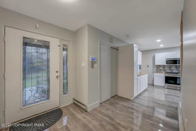 an empty room with wooden floor fireplace and windows