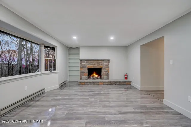 a view of empty room with wooden floor