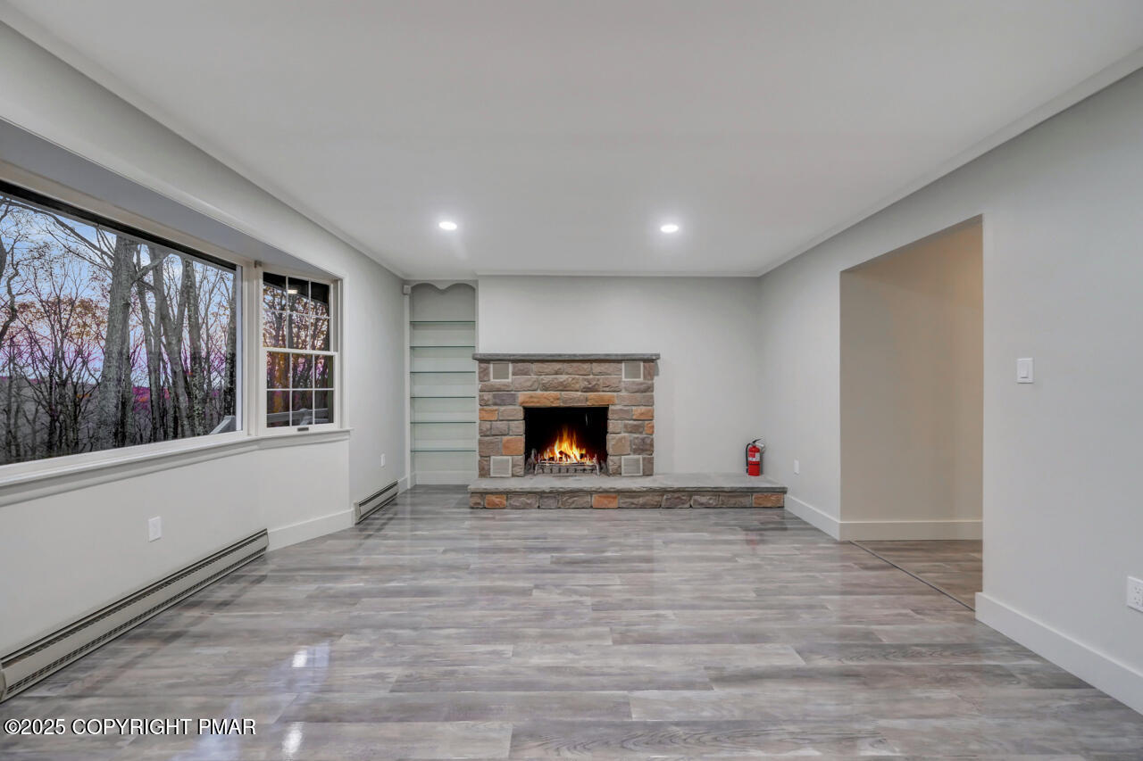 384 Devils Hole Road Cresco, PA 18326 - Photo 8 of 97 a view of an empty room with a fireplace and a window