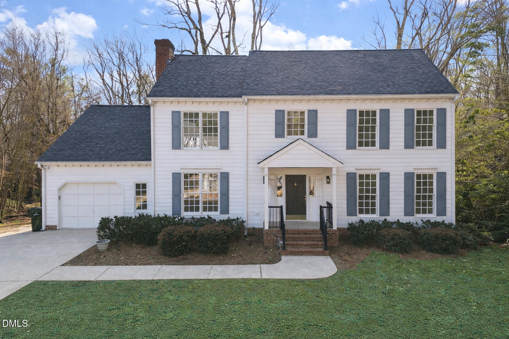 a front view of a house with a yard and trees