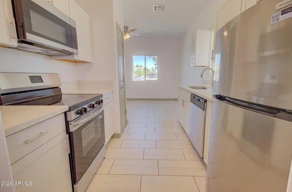 a kitchen with granite countertop white cabinets and white appliances