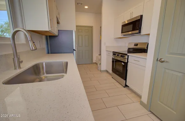 a kitchen with stainless steel appliances granite countertop a sink a stove a microwave and a refrigerator