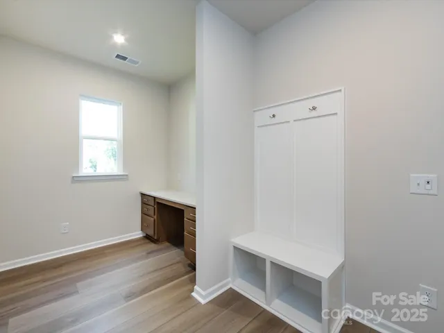 an empty room with wooden floor and window