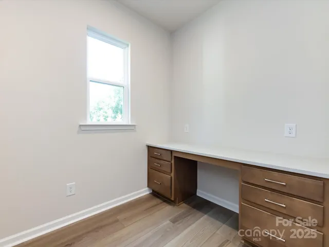 an empty room with wooden floor and window