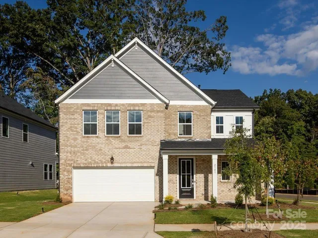a view of a white house with large windows and a small yard