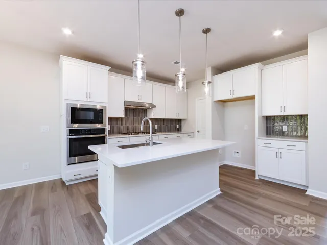 a kitchen with a sink stainless steel appliances and cabinets
