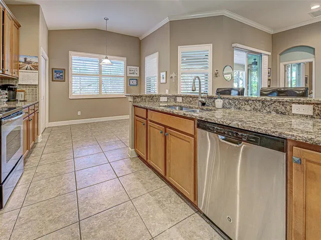 a kitchen with stainless steel appliances granite countertop a stove a sink and a refrigerator